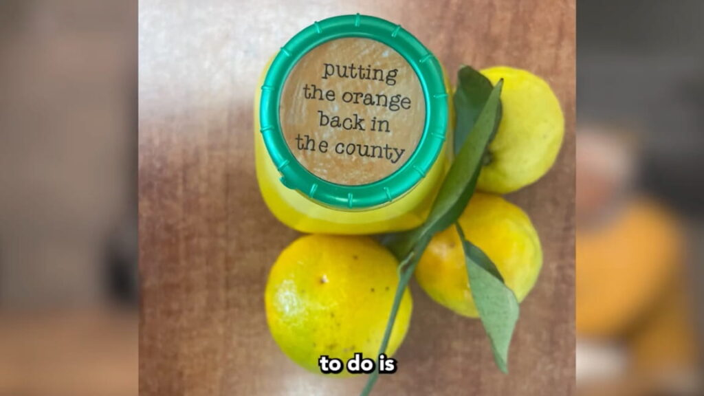 Bottle with "Putting the orange back in the county" message on the lid
